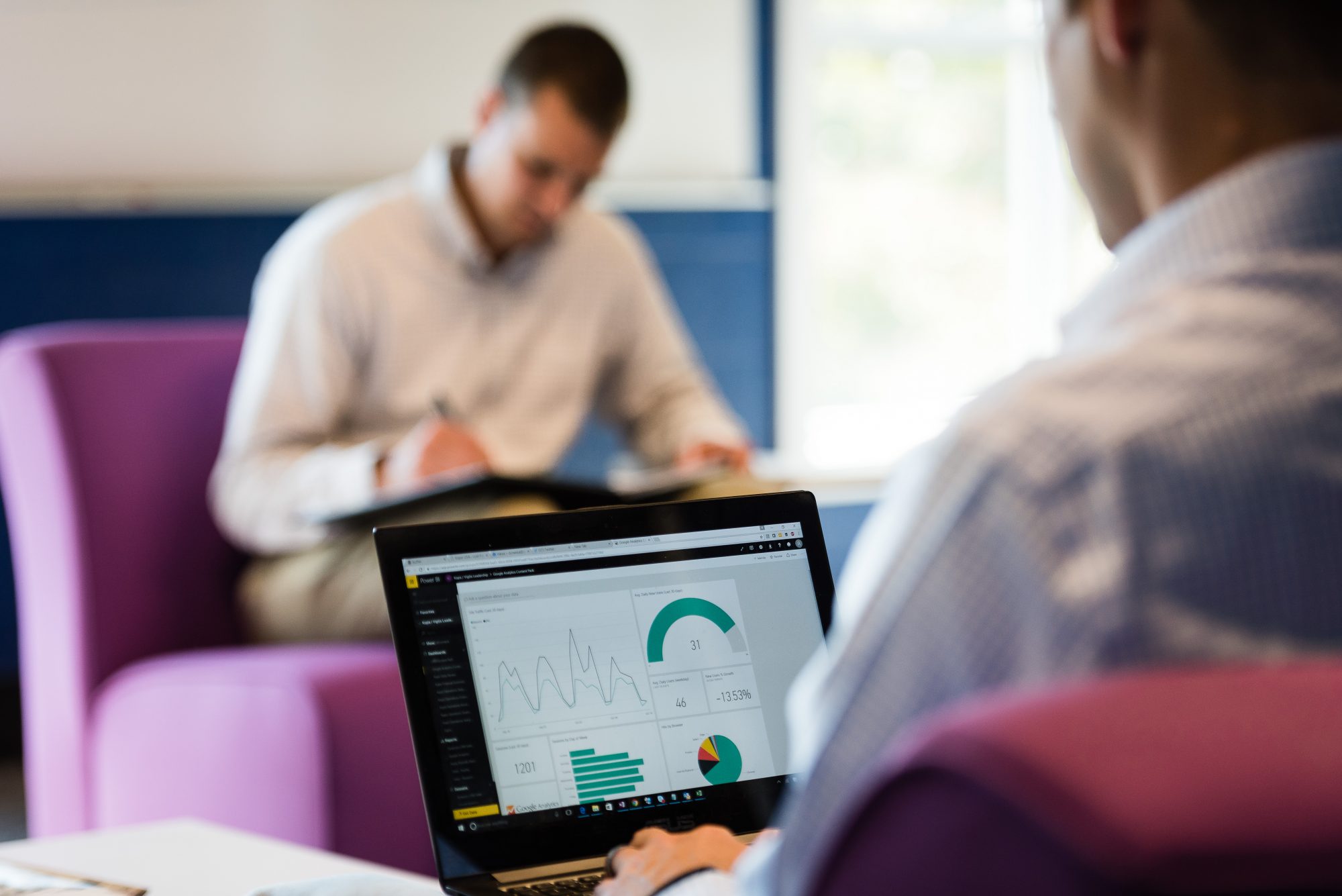 Man looking at laptop with business intelligence dashboard displayed