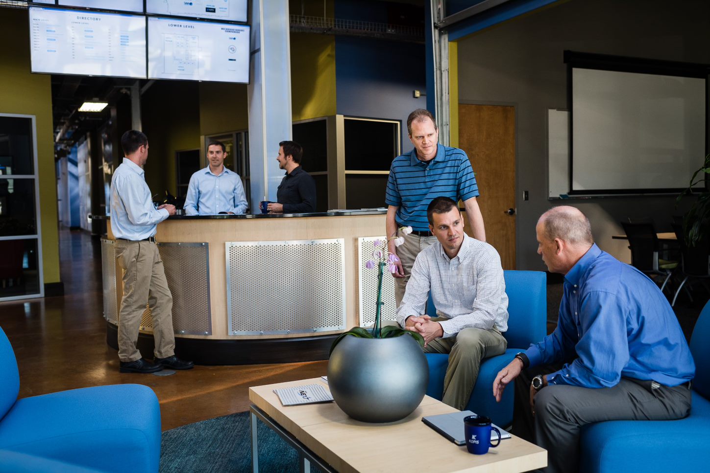 Group of guys talking in lobby of office